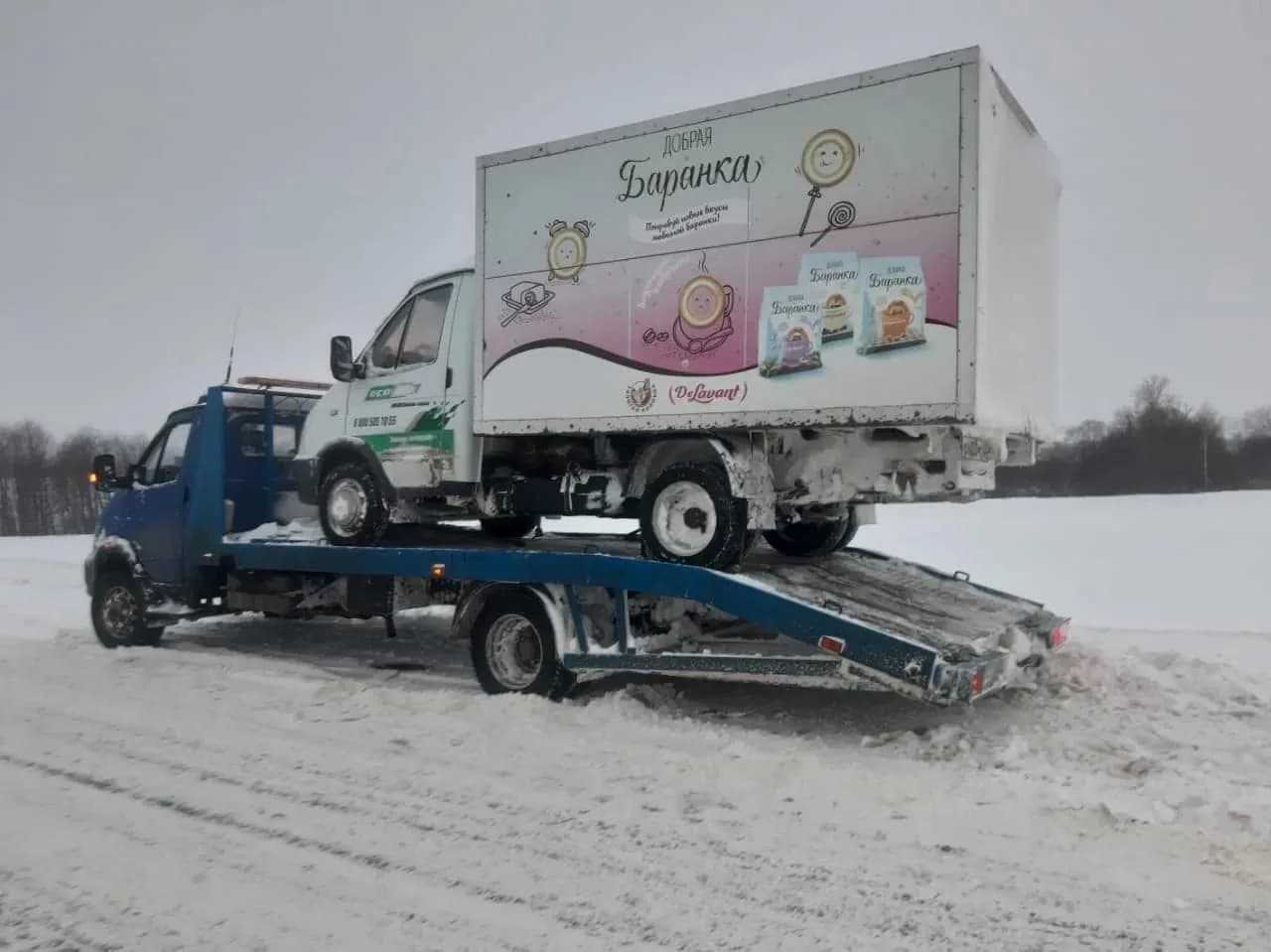 Грузовой фургон на эвакуаторе зимой