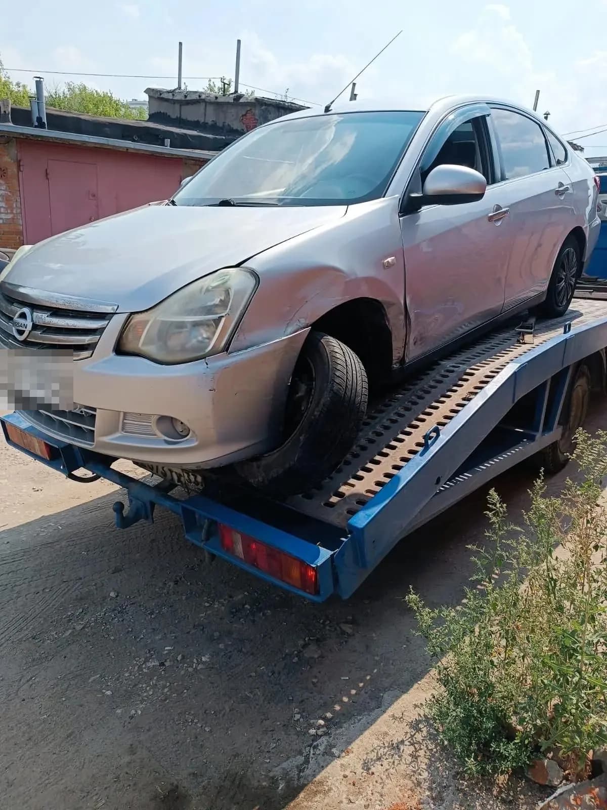 Повреждённый легковой автомобиль на платформе эвакуатора