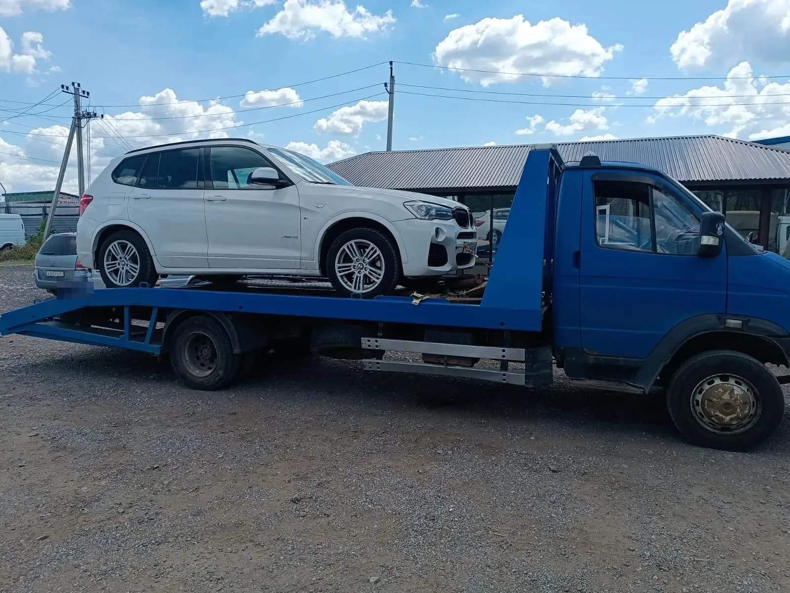 Белый внедорожник на синем эвакуаторе